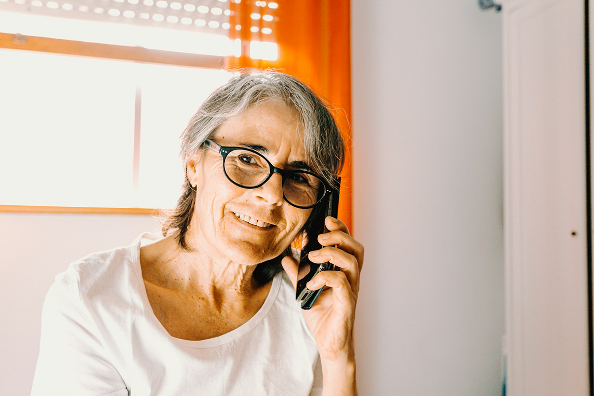 Woman wearing glasses talking on the phone at home